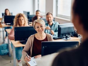 Glimlachende student maakt aantekeningen terwijl hij naar de leraar luistert Wat is een zelfstandig naamwoord vertaalbureau Antwerpen