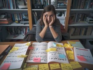 een leerling zit aan een bureau met een boek moeilijkste taal om te leren vertaalbureau Antwerpen